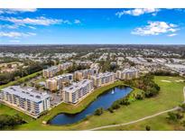Scenic aerial view of resort-style condos with a pond and golf course in a sunny, beautiful location at 960 Starkey Rd # 7503, Largo, FL 33771