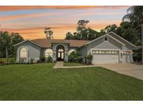 Beautiful single-story home featuring a well-manicured lawn and a three-car garage with a light gray exterior at 10113 Bell Creek Dr, Riverview, FL 33569