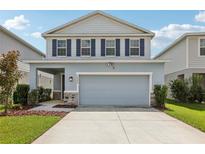 Charming two-story home featuring blue shutters, a two-car garage, and manicured landscaping at 10580 Gliding Eagle Way, Land O Lakes, FL 34638