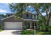Charming two-story home features a well-maintained front yard and a welcoming turquoise front door at 10605 Marsanne Pl, Riverview, FL 33578