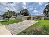 Charming single-story home with a brick facade, well-manicured lawn and curved driveway at 14047 Briardale Ln, Tampa, FL 33618