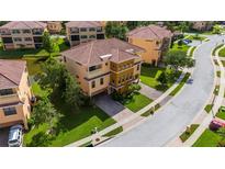 Stunning Mediterranean-style townhome with a tile roof, manicured lawn and brick paved driveway at 1536 Ember Ln, Tarpon Springs, FL 34689