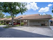 A carport with parking spaces and storage units for a residential townhome complex at 1933 Whitney Way, Clearwater, FL 33760