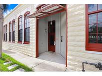 Welcoming exterior entrance featuring textured walls, awning, and red framed windows at 2001 E 2Nd Ave # 37, Tampa, FL 33605