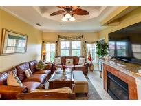 Inviting living room features a ceiling fan, fireplace, and comfortable leather furniture, perfect for relaxation and gatherings at 2724 Via Murano # 639, Clearwater, FL 33764