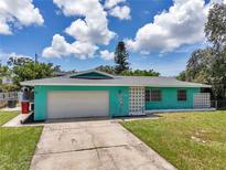 Charming, light blue single-story home featuring a one-car garage and a well-maintained lawn at 3119 Roberta St, Largo, FL 33771