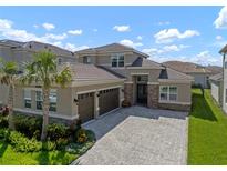 Beautiful exterior elevation features a well-manicured lawn, a three-car garage, and lovely stone accents at 3326 Acacia Bay Ave, Wesley Chapel, FL 33543