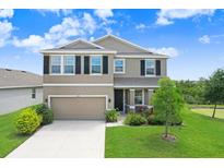 Charming two-story home featuring a well-manicured lawn, inviting entrance, and attached two car garage at 5430 Thistle Field Ct, Wesley Chapel, FL 33545