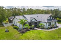 Charming single-Gathering home featuring a metal roof, screened-in porch and lush landscaping at 7725 235Th E St, Myakka City, FL 34251