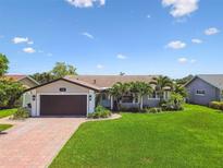 Charming single-story home with a well-manicured lawn, brick driveway and lush tropical landscaping at 1432 50Th Ne Ave, St Petersburg, FL 33703