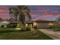 Charming single-story home featuring lush landscaping, mature trees, and an attached two-car garage at 1901 Paddock Dr, Plant City, FL 33566