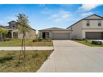 Charming one-story home with a well-manicured lawn, neutral paint, and attached garage at 3186 Oyster Cove St, Wimauma, FL 33598