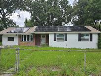 Charming home featuring white painted brick, modern solar panels, and a cozy front yard at 3614 E Grove St, Tampa, FL 33610