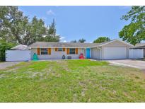 Charming single-story home with a well-manicured lawn and a bright blue front door at 540 Firefly Ln, Apollo Beach, FL 33572