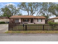 Charming single-story home with a well-maintained front yard and quaint picket fence at 5533 Golden Nugget Dr, Holiday, FL 34690