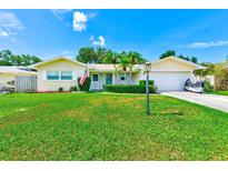 Charming single-story home with a well-maintained lawn, a two-car garage, and a cozy front porch at 11082 90Th Ter, Seminole, FL 33772