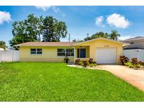 Charming yellow single-story home with a well-manicured lawn and attached garage, perfect curb appeal at 11398 88Th Ave, Seminole, FL 33772