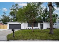 Charming single-story home featuring a freshly painted exterior, complemented by a well-manicured lawn and mature trees at 1506 Winding W Way, Clearwater, FL 33764