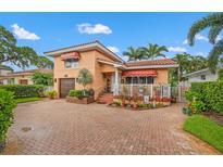 Charming two-story home featuring a beautiful tile roof, red awnings, and a brick-paved driveway at 243 Snell Isle Ne Blvd, St Petersburg, FL 33704