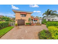 Charming home showcasing a red tile roof, awnings, a well-manicured lawn, and a brick-paved driveway at 243 Snell Isle Ne Blvd, St Petersburg, FL 33704