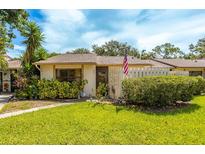 Charming single-story home featuring a well-manicured lawn, mature landscaping, and a quaint picket fence at 2922 60Th W St, Bradenton, FL 34209