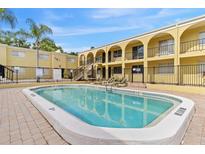 Inviting community pool surrounded by lush landscaping and lounge chairs at 3206 W Azeele St # 120, Tampa, FL 33609