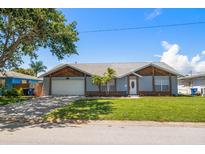 Charming single-story home featuring a well-manicured lawn, mature trees, and an attached two-car garage at 3831 Yardley N Ave, St Petersburg, FL 33713