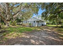 Charming single-story home featuring a new deck, mature trees, and fresh exterior paint at 44912 Lacoochee Claysink Rd, Webster, FL 33597