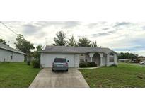Charming single-story home with an attached garage and well-maintained front lawn and garden area at 5244 Hanford Ave, Spring Hill, FL 34608