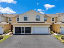 Inviting townhouse featuring an attached two-car garage and well-maintained landscaping at 6400 46Th N Ave # 61, Kenneth City, FL 33709