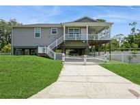 Inviting two-story home with a spacious covered porch and a well-manicured front lawn and white picket fence at 9107 Brunswick Ln, Tampa, FL 33615