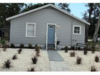 Charming single-story home with a light blue door and tidy landscaping at 921 Grand Central St, Clearwater, FL 33756