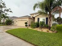 Charming single-story home featuring a well-manicured lawn and a two-car garage at 10747 Laxer Cay Loop, San Antonio, FL 33576