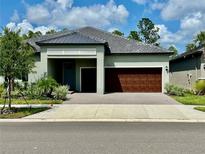 Charming single-story home with well-manicured landscaping and a brick driveway at 10864 Banyan Breeze Blvd, Land O Lakes, FL 34638