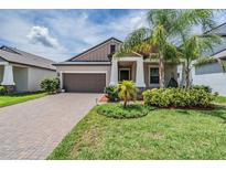 Charming single-Gathering home with a well-manicured lawn, beautiful landscaping, and a brick-paved driveway at 11315 Chilly Water Ct, Riverview, FL 33579