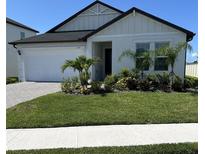 Charming single-story home with a well-manicured lawn, lush landscaping, and a welcoming front entrance at 11717 74Th E Cir, Palmetto, FL 34221