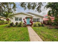 Charming single-story home with lush landscaping and a vibrant blue front door at 121 28Th N Ave, St Petersburg, FL 33704