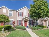 Charming townhome featuring a well manicured lawn, colorful front door and red shutters at 1415 Sedgwick Dr, Wesley Chapel, FL 33543