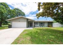 Charming single-story home features a well-manicured lawn, a two-car garage, and a welcoming front entrance at 1461 S Hillcrest Ave, Clearwater, FL 33756
