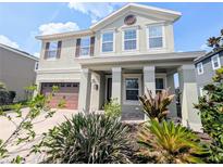 Charming two-story home featuring a covered front porch and a well-manicured, landscaped front yard at 32599 Natural Bridge Rd, Wesley Chapel, FL 33543