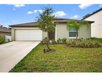 Charming single-story home featuring a two-car garage and a well-manicured lawn with young trees at 36618 Garden Wall Way, Zephyrhills, FL 33541
