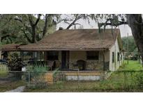 Modest one-story home with a covered porch and overgrown landscaping needs major repairs at 4009 N 15Th St, Tampa, FL 33610