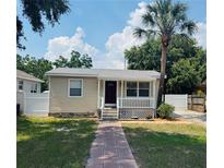 Charming single-story home featuring a cozy front porch, well-kept lawn, and attractive landscaping at 4111 W Grace St, Tampa, FL 33607