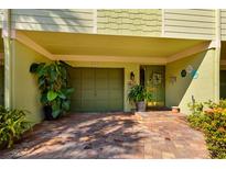 Inviting condo exterior showcasing a garage and charming front door with brick-paved parking at 505 Sandy Hook Rd # 505, Treasure Island, FL 33706