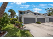Charming two-story townhome features a two-car garage, well-maintained landscaping, and inviting curb appeal at 9205 Jakes Path, Largo, FL 33771