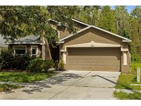 Charming home featuring a two-car garage, neutral-tone stucco, and well-maintained landscaping at 10462 Lucaya Dr, Tampa, FL 33647