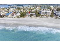Stunning aerial view of beach home on the ocean with clear, turquoise water at 12458 1St W St, Treasure Island, FL 33706