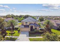 Beautiful two-story home featuring a well-manicured lawn and a black metal roof at 1314 Oak Pond St, Ruskin, FL 33570