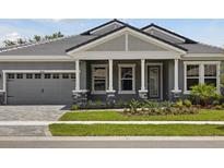 Charming single-story home showcasing a well-manicured lawn, stone accents, and an attached two-car garage at 14523 Swiss Bridge Dr, Lithia, FL 33547