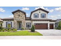 Beautiful two-story home featuring a stone facade, symmetrical design, and a well-manicured lawn at 14531 Swiss Bridge Dr, Lithia, FL 33547